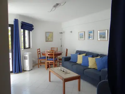 a living room with a blue couch and a table at Porto Marina @Vilamoura in Vilamoura