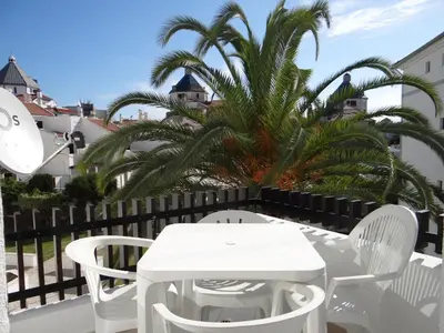 a white table and chairs on a balcony with a palm tree at Porto Marina @Vilamoura in Vilamoura