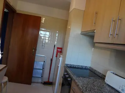 a small kitchen with a refrigerator and a door at Porto Marina @Vilamoura in Vilamoura