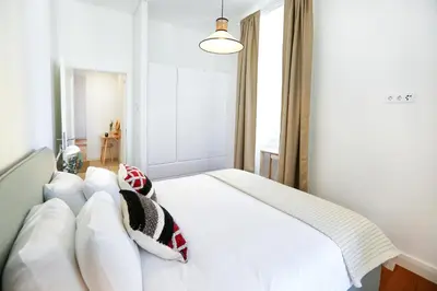 a bedroom with a white bed with pillows at Ice Cream Call Apartments in Faro