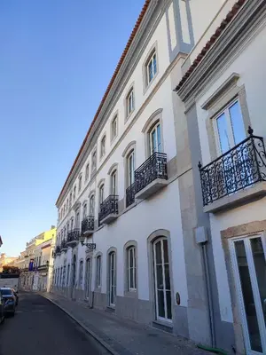 a large white building with balconies on a street at Ice Cream Call Apartments in Faro