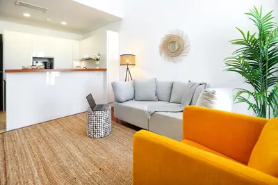 a living room with a couch and a kitchen at Querido Algarve Apartment in Faro