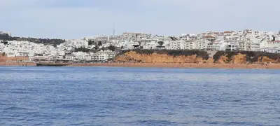 a view of a beach with white buildings in the background at Casa Docim, casa tipica algarvia no centro da cidade velha in Albufeira