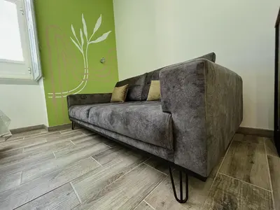 a bedroom with a bed and a blue couch at Leevin Guesthouse in Faro
