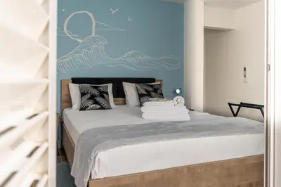a bedroom with a bed with a desk and a green wall at Leevin Guesthouse in Faro