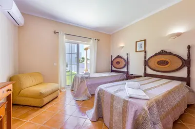 a bedroom with a bed and a chair and a window at Villa Ocre in Galé