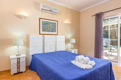 a bedroom with a blue bed with towels on it at Villa Ocre in Galé