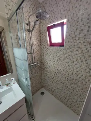 a bathroom with a shower and a sink and a mirror at Apartamento Batalha - Quarteira, Algarve, Portugal in Quarteira