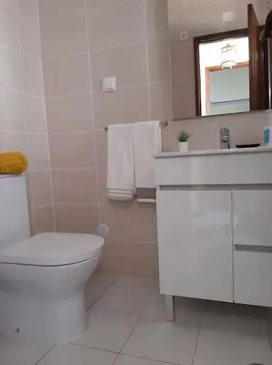 a white bathroom with a toilet and a sink at Apartamento Batalha - Quarteira, Algarve, Portugal in Quarteira