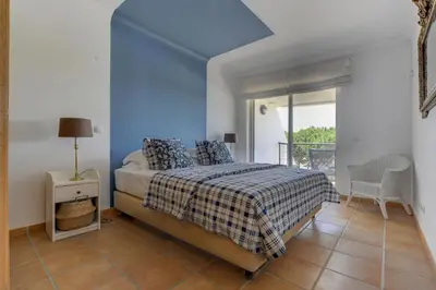 a bedroom with a bed with a blue wall at Vila Sol Apartamento fantástico 3 quartos piscina in Quarteira