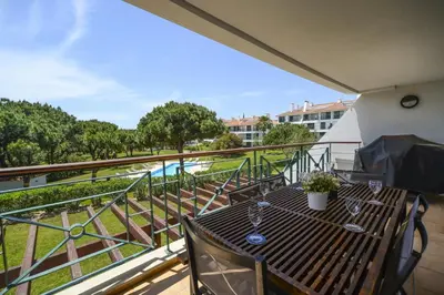 a balcony with a table and chairs and a view at Vila Sol Apartamento fantástico 3 quartos piscina in Quarteira