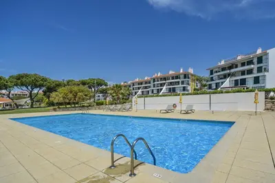 a swimming pool in a building with buildings in the background at Vila Sol Apartamento fantástico 3 quartos piscina in Quarteira