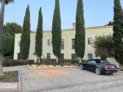 a black car parked in front of a building with trees at Quinta do Lago 2-Bed Apartment - Golf Pool & Ac in Faro