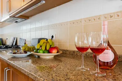 two glasses of wine sitting on a counter in a kitchen at V3 Olhos dÁgua com piscina AC wifi 800m praia in Olhos de Água