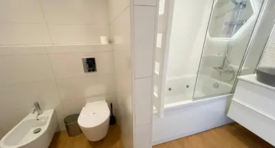 a white bathroom with a toilet and a sink at Penthouse Triplex com Jacuzzi T3 HsR Vilamarina in Vilamoura