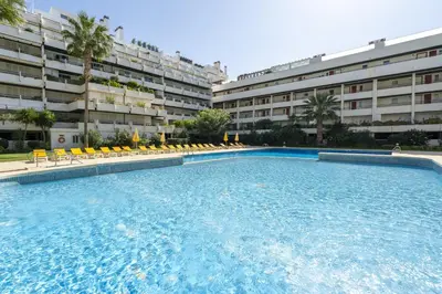 a large swimming pool in front of a building at Penthouse Triplex com Jacuzzi T3 HsR Vilamarina in Vilamoura