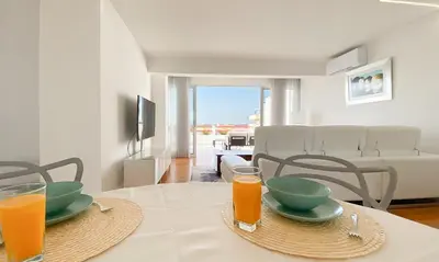 a table with two glasses of orange juice on it at Penthouse Triplex com Jacuzzi T3 HsR Vilamarina in Vilamoura