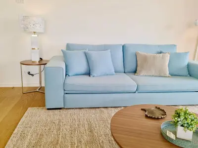 a blue couch in a living room with a table at La Vila Nature, Laguna Village 246-Clever Details, Luxury apartment, located in a quiet area, BBQ and free Wi-Fi in Vilamoura