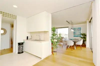 a kitchen and dining room with white cabinets and a table at La Vila Nature, Laguna Village 246-Clever Details, Luxury apartment, located in a quiet area, BBQ and free Wi-Fi in Vilamoura