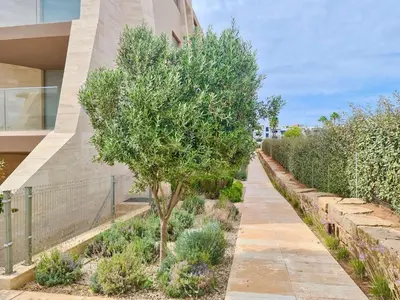 a tree on a sidewalk next to a building at La Vila Nature, Laguna Village 246-Clever Details, Luxury apartment, located in a quiet area, BBQ and free Wi-Fi in Vilamoura