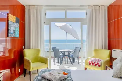 a bedroom with a table and chairs and an umbrella at Monicca Collection Suites and Residences in Albufeira