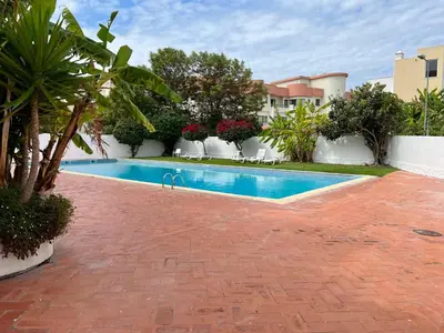a swimming pool in a yard next to a house at Casa da Praia - Santa Eulália Beach in Albufeira