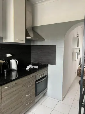 a kitchen with a black counter top and a stove at Casa da Praia - Santa Eulália Beach in Albufeira