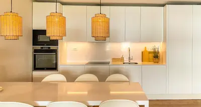 a kitchen with white cabinets and a table and chairs at YES! Incrível Vista Piscina T2 HsR Vilamarina in Vilamoura