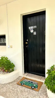 a black door with a mat in front of it at Albufeira Home in Albufeira