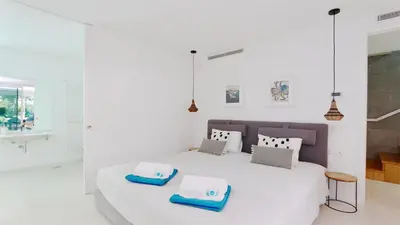 a white bedroom with a white bed with two towels on it at Villa Miya - Clever Details, walking distance from the Marina, restaurants, bakeries and supermarkets,, free wifi, pool in Vilamoura