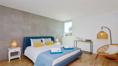 a bedroom with a bed with blue and yellow pillows at Villa Miya - Clever Details, walking distance from the Marina, restaurants, bakeries and supermarkets,, free wifi, pool in Vilamoura