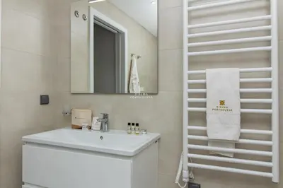 a white bathroom with a sink and a mirror at Apartment Terracos do Mar - By Dalma Portuguesa in Quarteira