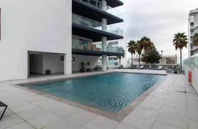 a swimming pool in front of a building at Apartment Terracos do Mar - By Dalma Portuguesa in Quarteira