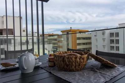 a table with a basket of bread on a balcony at Apartment Terracos do Mar - By Dalma Portuguesa in Quarteira