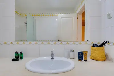a white sink in a bathroom with a mirror at JAZZ & SILVIA - Moderno & Central apenas a 5 min da praia dos Pescadores in Albufeira