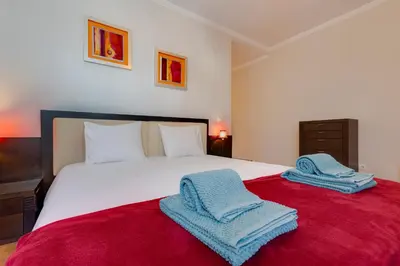 a bedroom with a large bed with towels on it at JAZZ & SILVIA - Moderno & Central apenas a 5 min da praia dos Pescadores in Albufeira