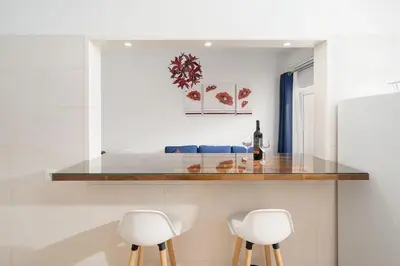 a kitchen with two white stools and a counter top at My Place @ Faro Skyline in Faro