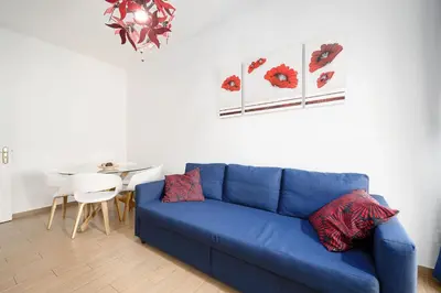 a blue couch in a living room with a table at My Place @ Faro Skyline in Faro