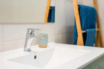 a bathroom sink with a faucet and a mirror at My Place @ Faro Skyline in Faro