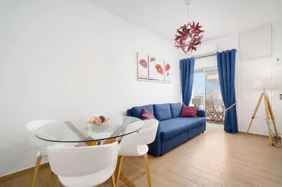 a living room with a blue couch and a glass table at My Place @ Faro Skyline in Faro