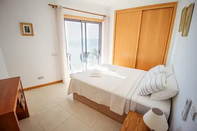 a bedroom with a bed and a large window at Excellent Sea view 1 Bedroom Apartment, Verandas do Mar, Olhos de Agua AT05 in Olhos de Água