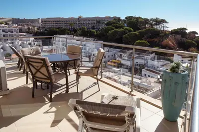 a balcony with a table and chairs and a view of a city at Excellent Sea view 1 Bedroom Apartment, Verandas do Mar, Olhos de Agua AT05 in Olhos de Água
