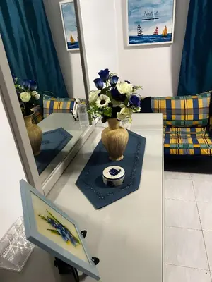 a living room with a table with a vase of flowers at Mouramar Vilamoura in Vilamoura