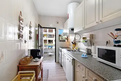 a kitchen with white cabinets and a counter top at Mouramar Vilamoura in Vilamoura