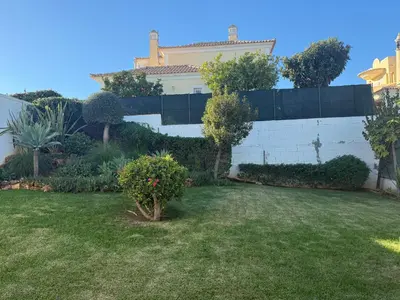 a yard in front of a white wall with plants at Casa SP- Villa with heated pool near Vilamoura, Vale do Lobo in Quarteira