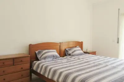a bedroom with a bed with a wooden headboard and a dresser at Cosy flat, Salgados Village in Guia