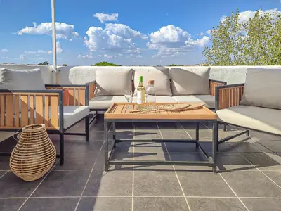 a patio with couches and a table on a roof at Loft Quinta da Balaia - Jacuzzi - By BEDZY in Albufeira