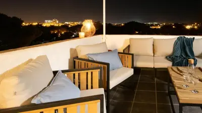 a balcony with couches and a table and a view at Loft Quinta da Balaia - Jacuzzi - By BEDZY in Albufeira