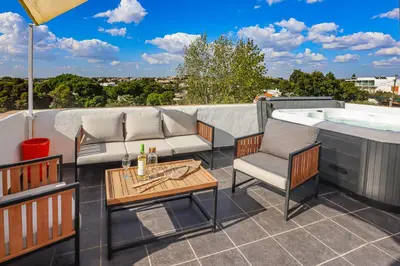 a patio with a tub and chairs and a table at Loft Quinta da Balaia - Jacuzzi - By BEDZY in Albufeira