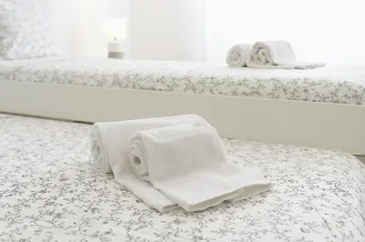 two beds with white towels on the floor in a room at Host Wise - Sweet & Sunny Flat - Ace Location in Quarteira